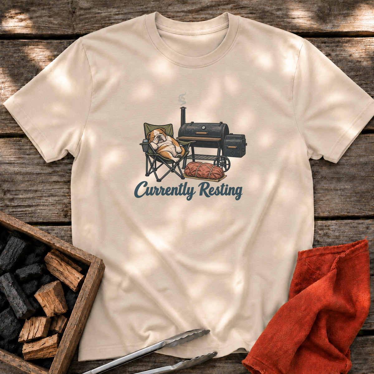 Sand T-shirt with the design “Currently Resting” printed on the front.