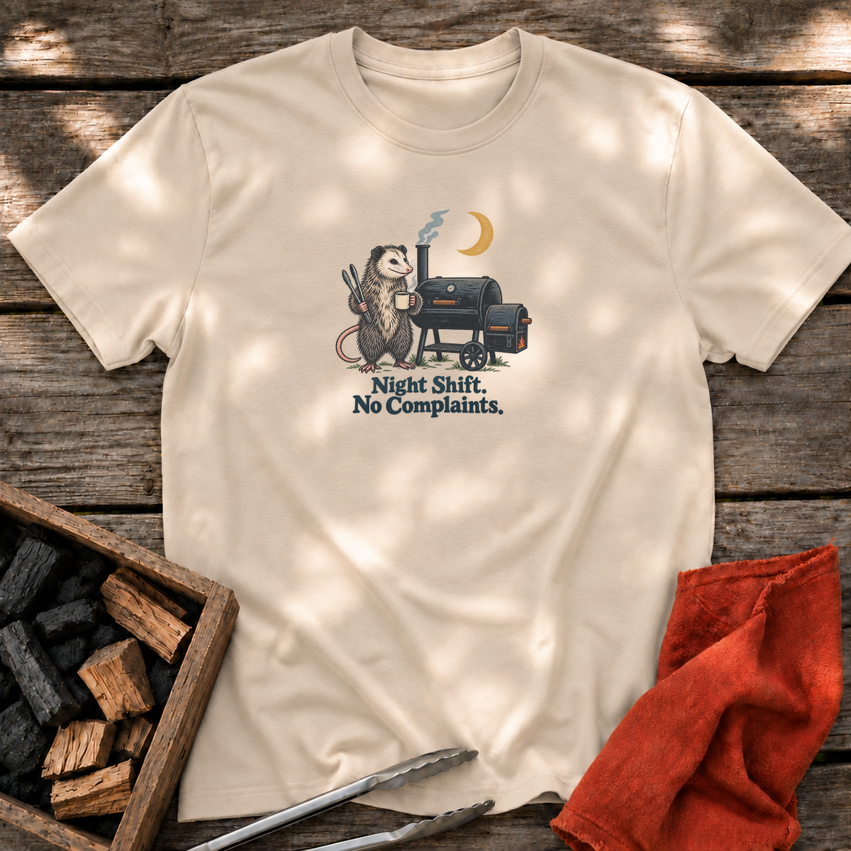Sand T-shirt with the design “Night Shift. No Complaints.” printed on the front.