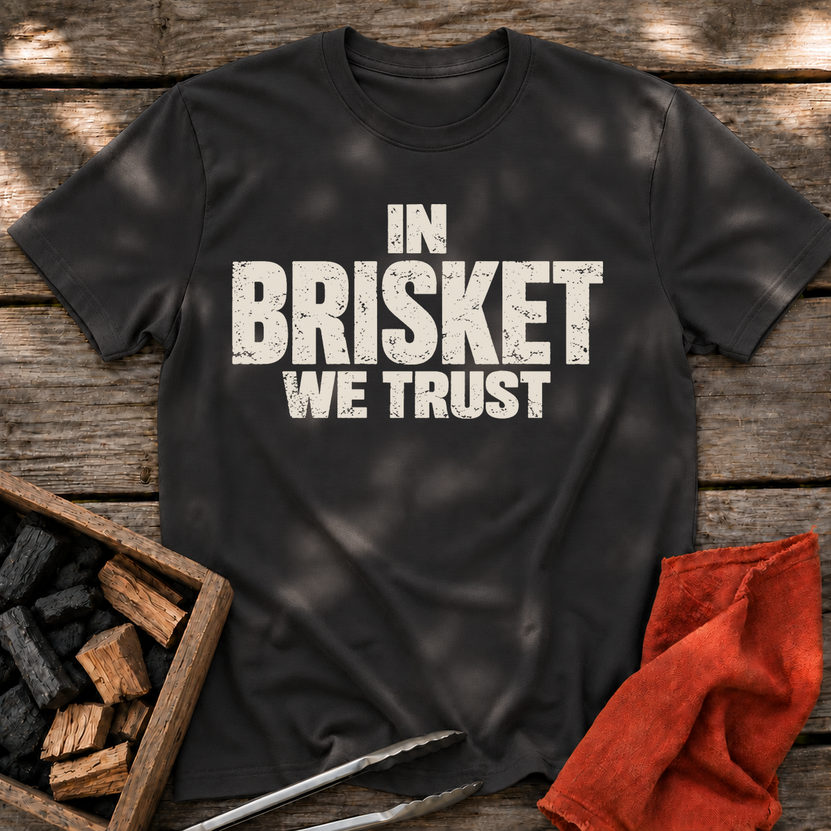 Black T-shirt with the design “In Brisket We Trust.” printed on the front.