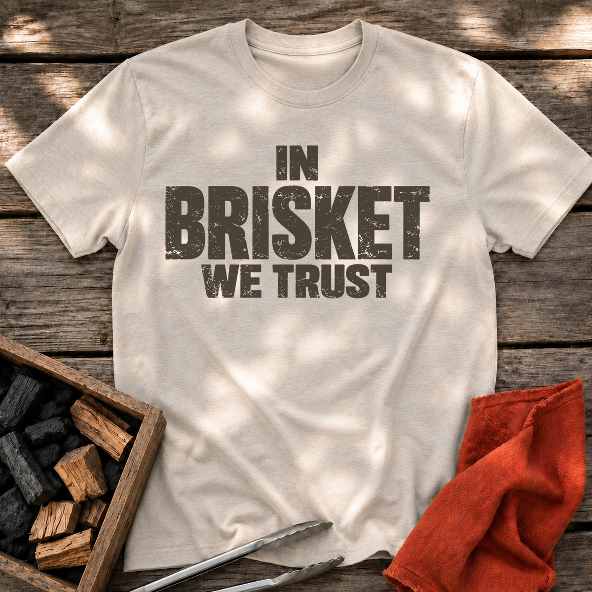 Natural T-shirt with the design “In Brisket We Trust.” printed on the front.
