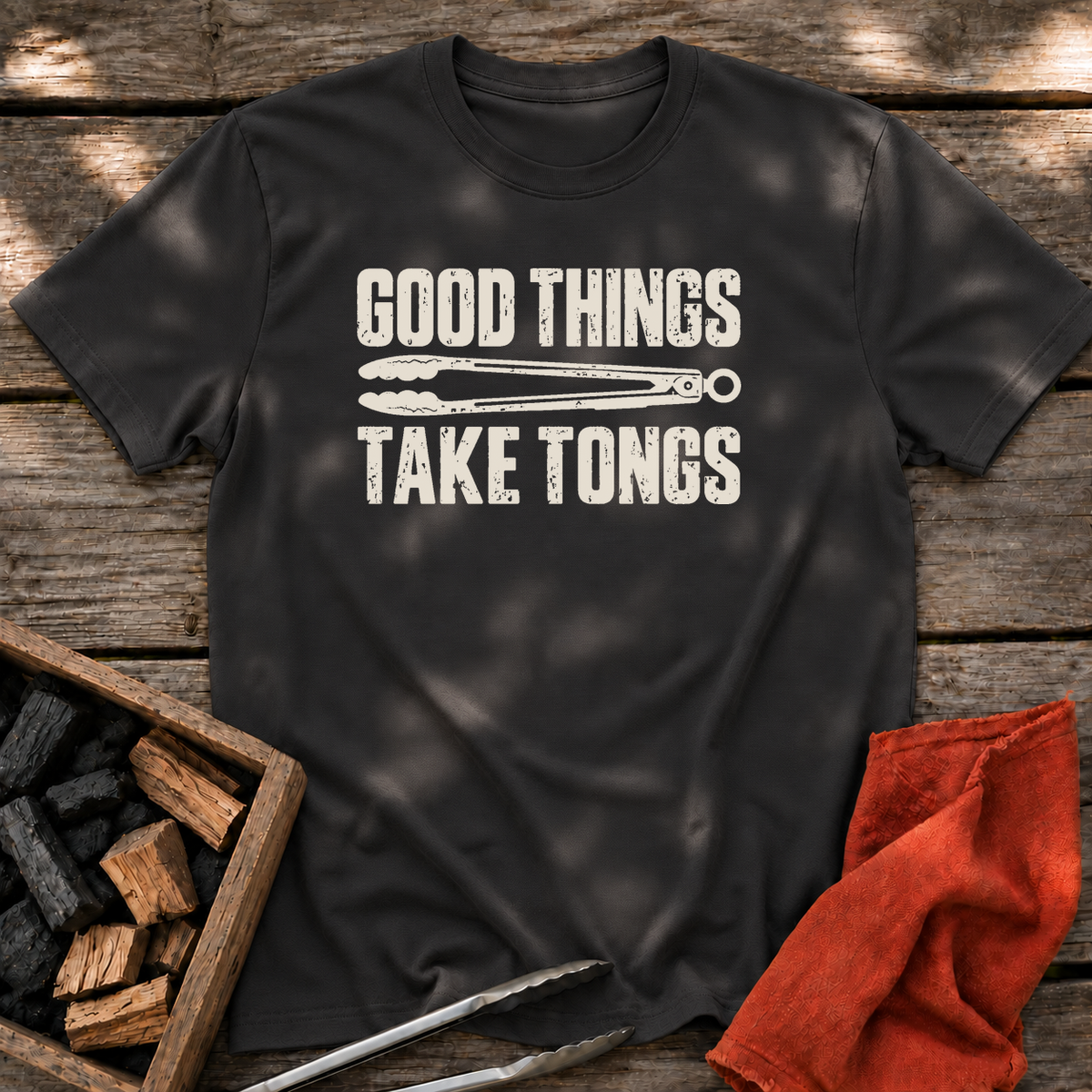 Black T-shirt with the design “GOOD THINGS TAKE TONGS” printed on the front.