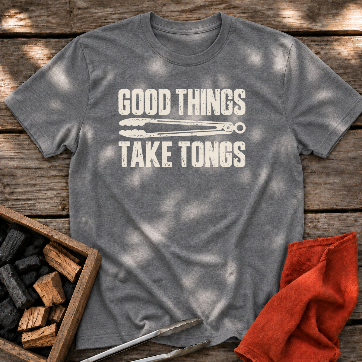 Graphite Heather T-shirt with the design “GOOD THINGS TAKE TONGS” printed on the front.