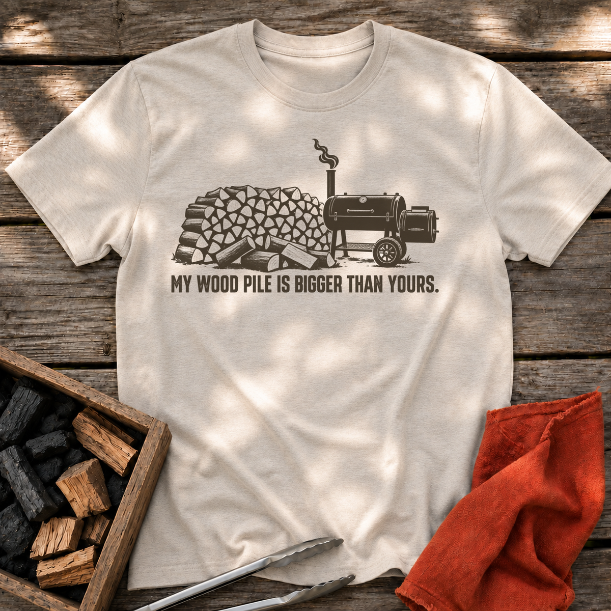 Natural T-shirt with the design “My Wood Pile is Bigger Than Yours” printed on the front.