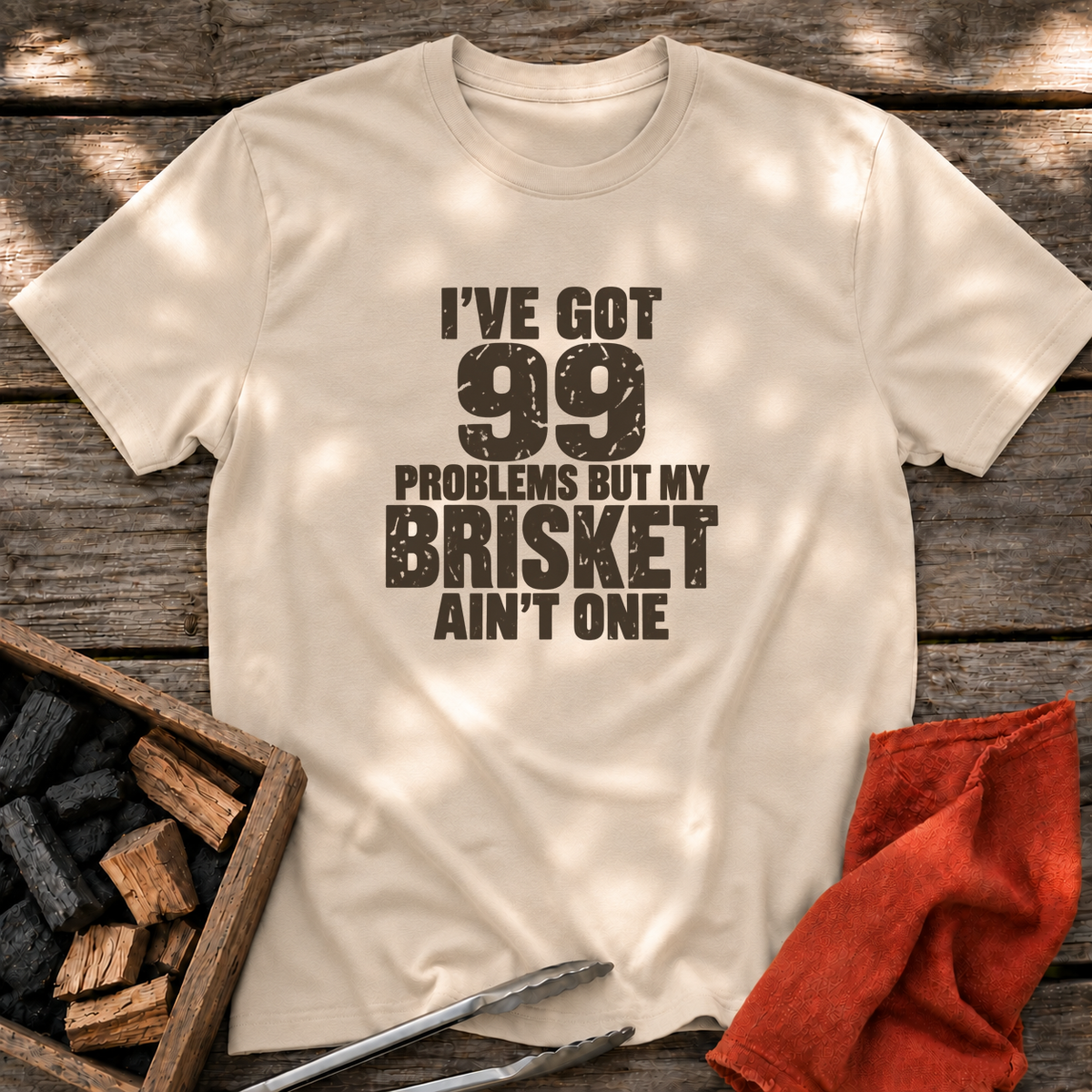 Sand T-shirt with the design “I've Got 99 Problems But My Brisket Ain't One” printed on the front.