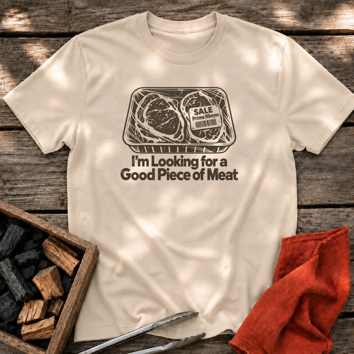Sand T-shirt with the design “I'm Looking for a Good Piece of Meat” printed on the front.