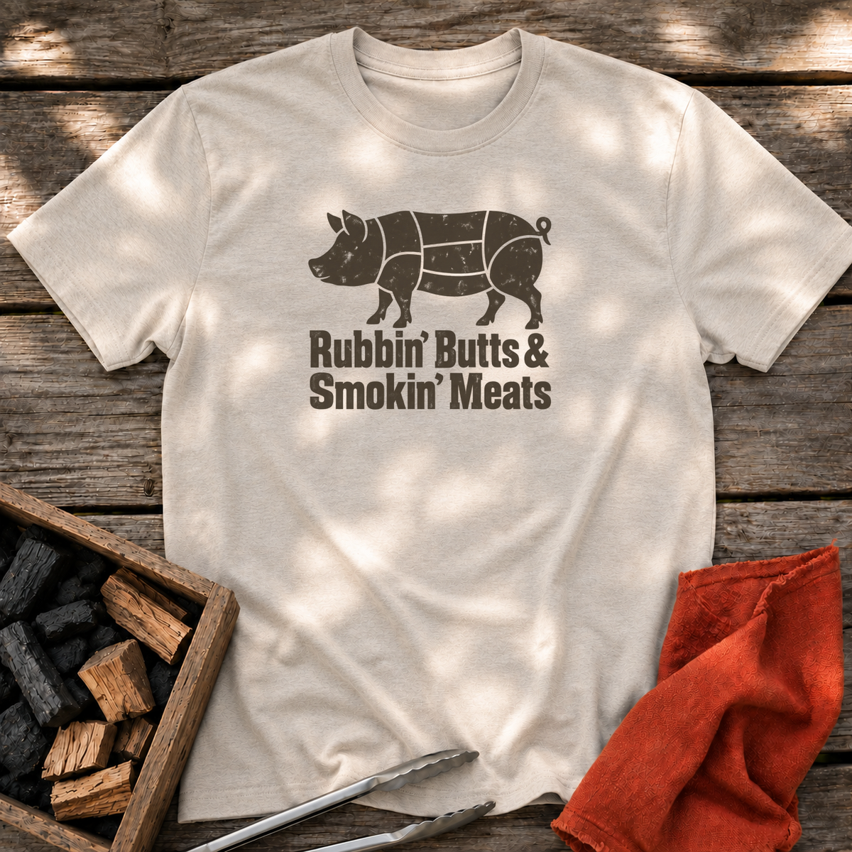 Natural T-shirt with the design “Rubbin' Butts & Smokin' Meats” printed on the front.