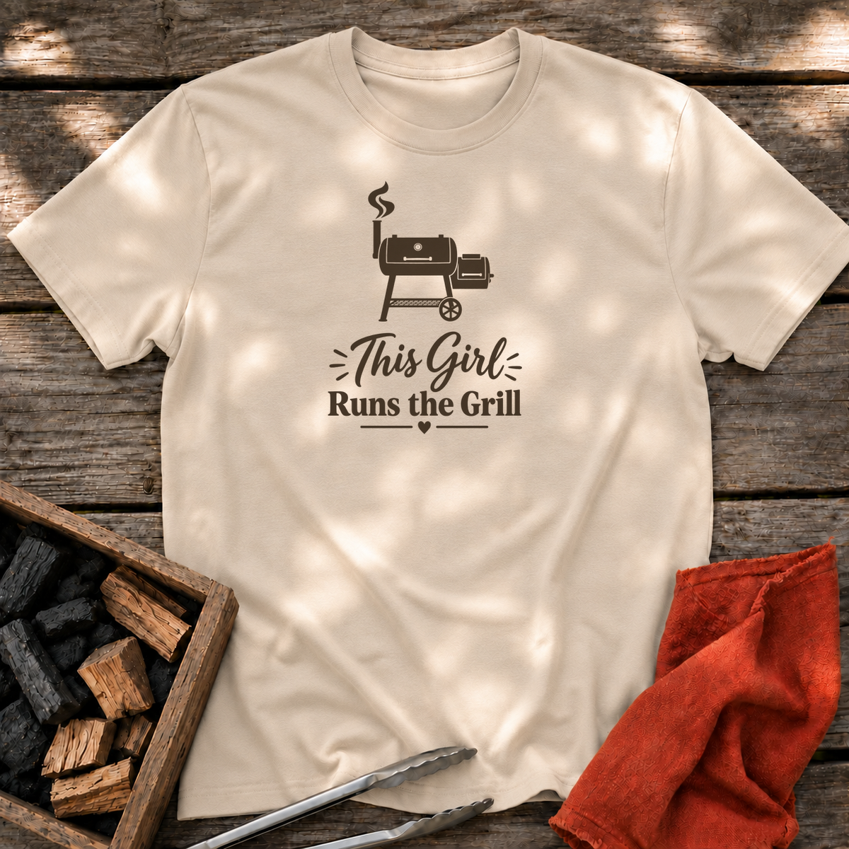 Sand T-shirt with the design “This Girl Runs the Grill” printed on the front.