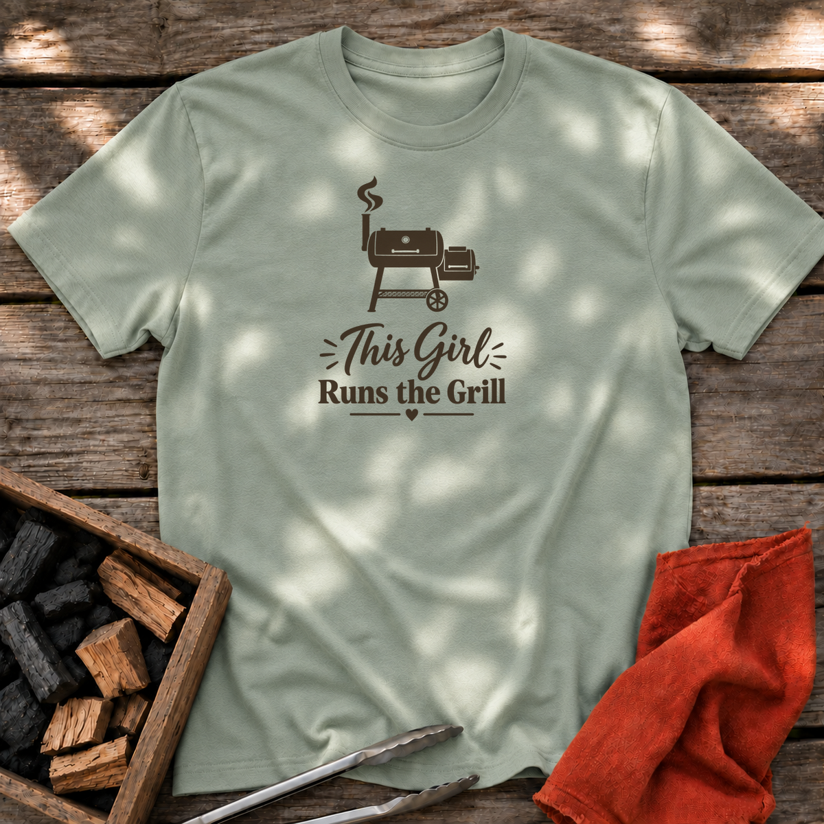 Sage T-shirt with the design “This Girl Runs the Grill” printed on the front.