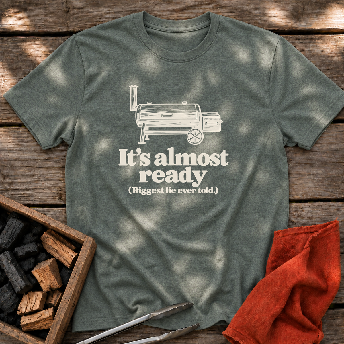 Heather Military Green T-shirt with the design “It's almost ready (Biggest lie ever told.)” printed on the front.