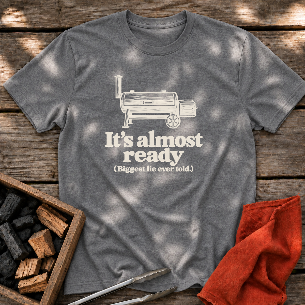 Graphite Heather T-shirt with the design “It's almost ready (Biggest lie ever told.)” printed on the front.