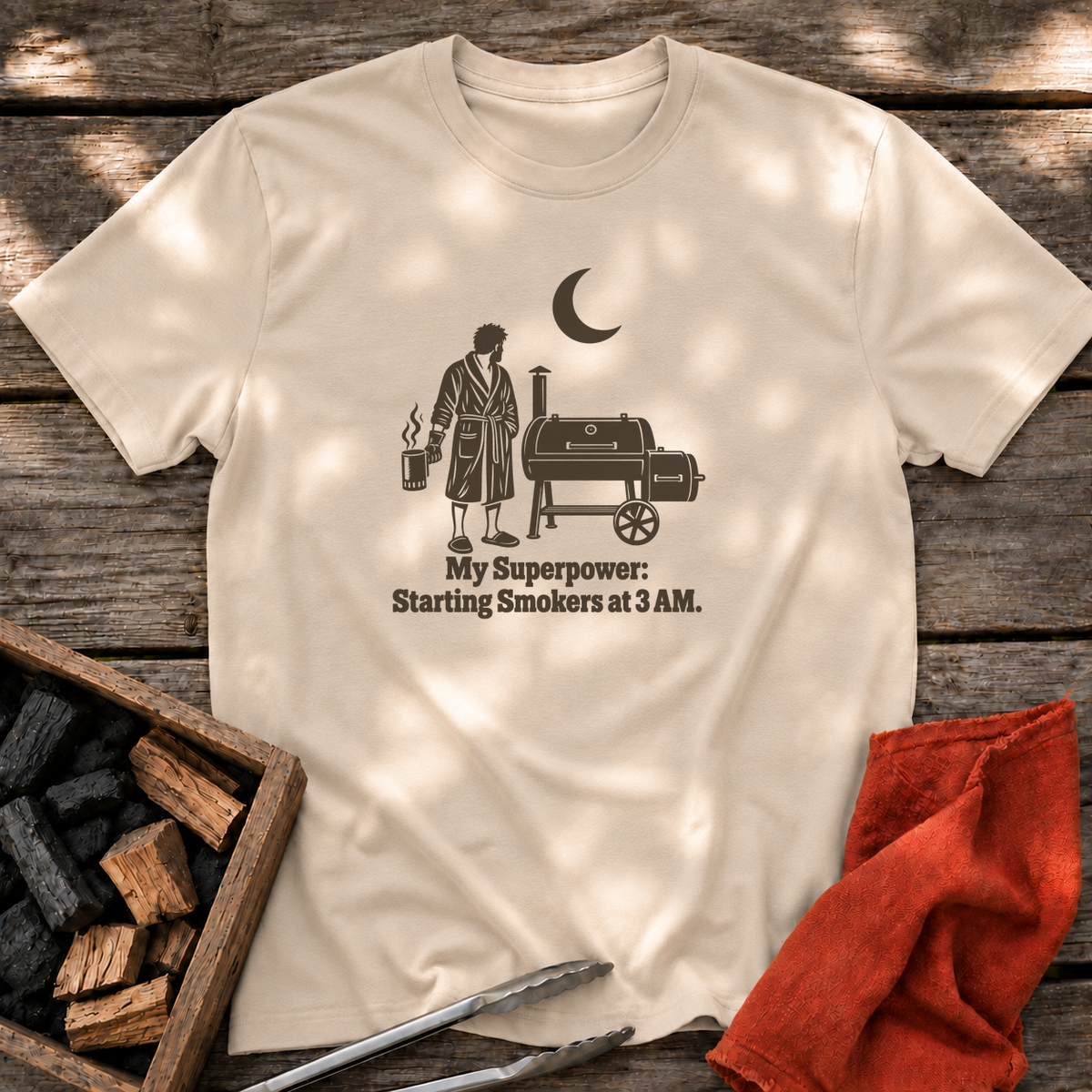 Sand T-shirt with the design “My Superpower: Starting Smokers at 3 AM.” printed on the front.