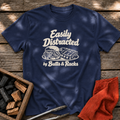 Navy T-shirt with the design “Easily Distracted by Butts & Racks” printed on the front.