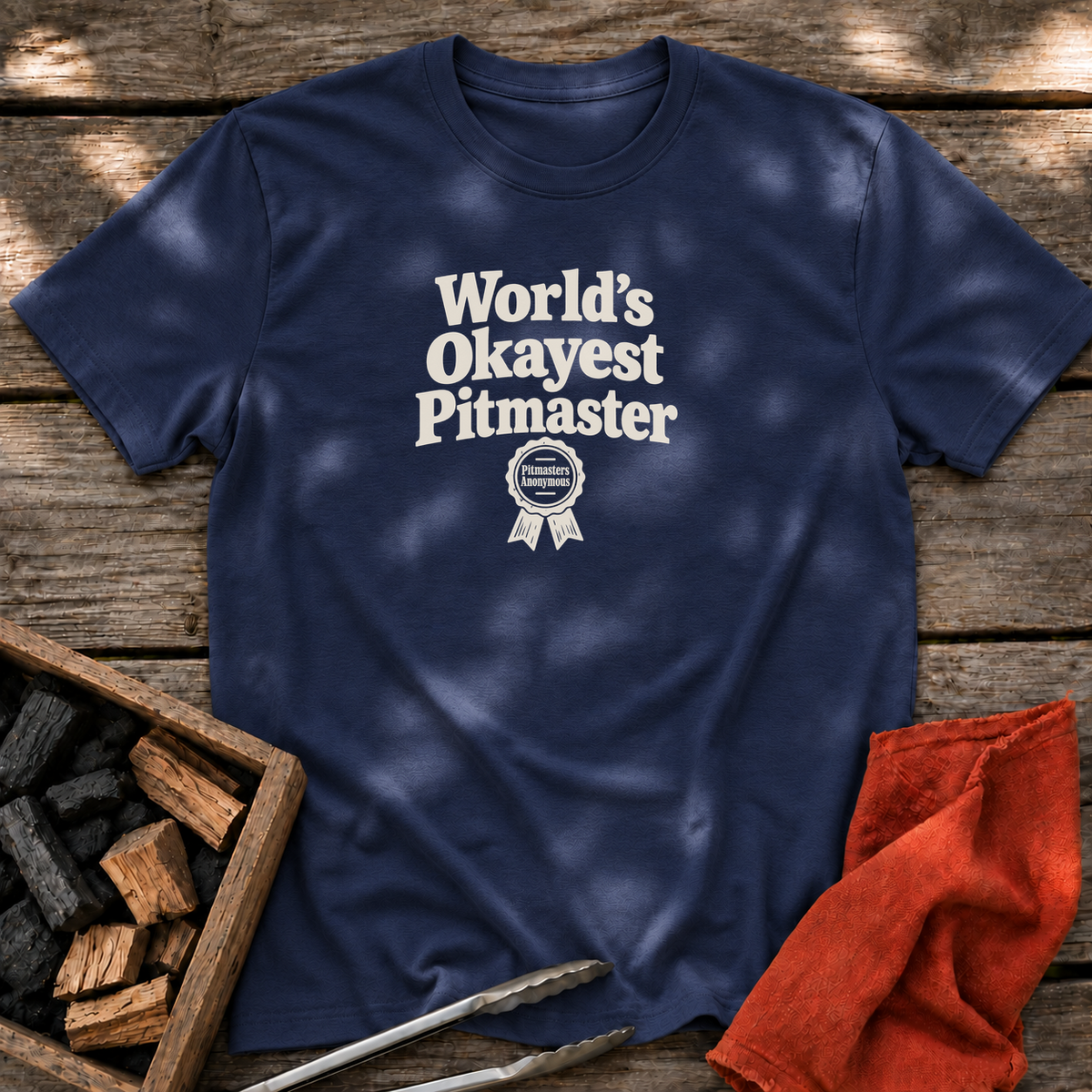 Navy T-shirt with the design “World’s Okayest Pitmaster” printed on the front.