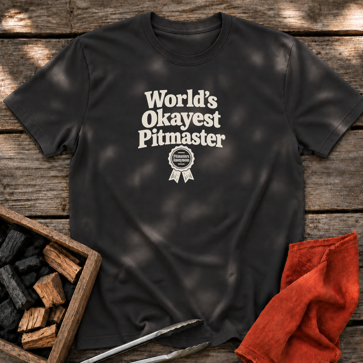 Black T-shirt with the design “World’s Okayest Pitmaster” printed on the front.