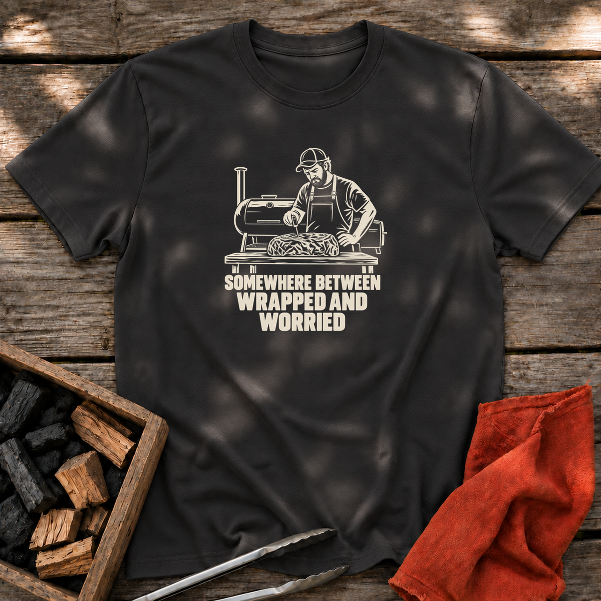 Black T-shirt with the design “SOMEWHERE BETWEEN WRAPPED AND WORRIED” printed on the front.