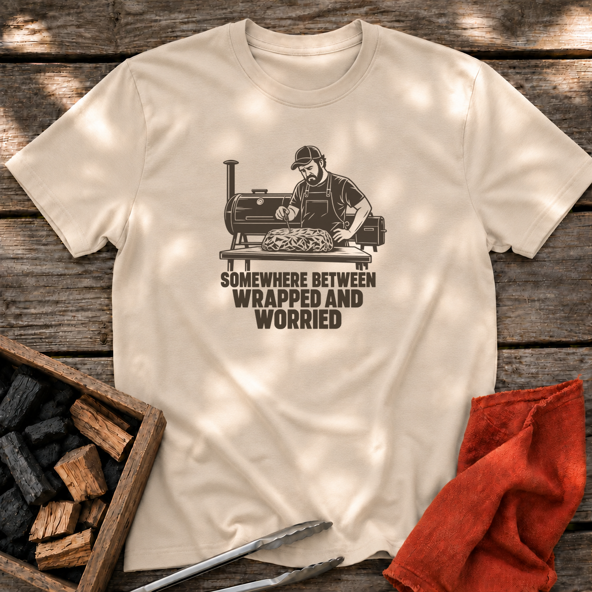 Sand T-shirt with the design “SOMEWHERE BETWEEN WRAPPED AND WORRIED” printed on the front.