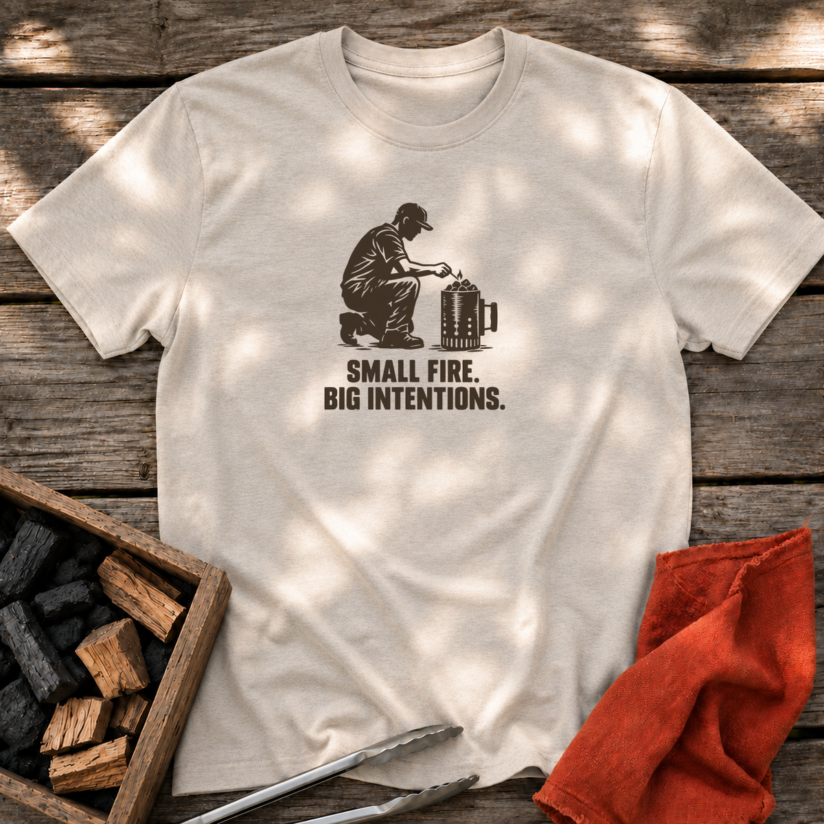 Natural T-shirt with the design “SMALL FIRE. BIG INTENTIONS.” printed on the front.