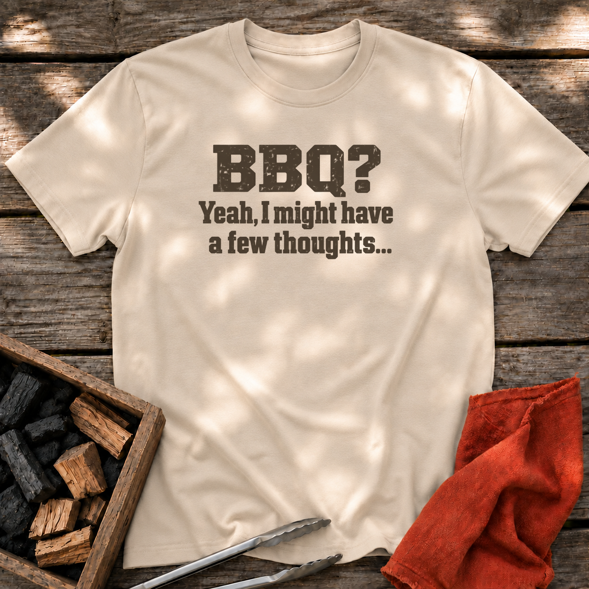Sand T-shirt with the design “BBQ? Yeah, I might have a few thoughts…” printed on the front.