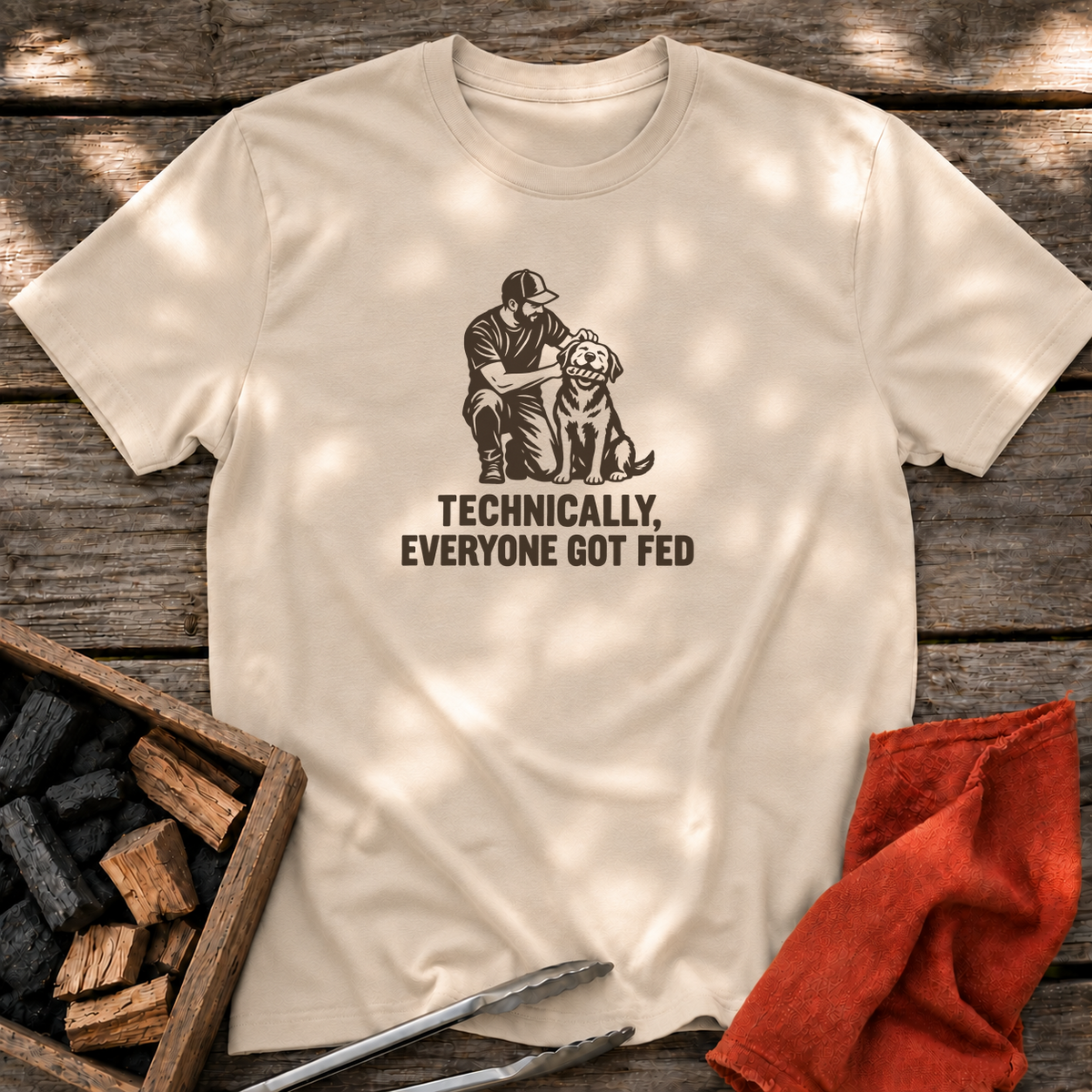 Sand T-shirt with the design “TECHNICALLY, EVERYONE GOT FED” printed on the front.