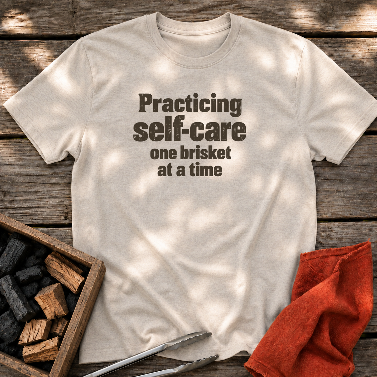Natural T-shirt with the design “Practicing self-care one brisket at a time.” printed on the front.
