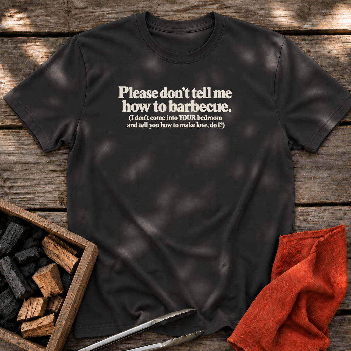 Black T-shirt with the design “Please don't tell me how to barbecue. (I don't come into YOUR bedroom and tell you how to make love, do I?)” printed on the front.