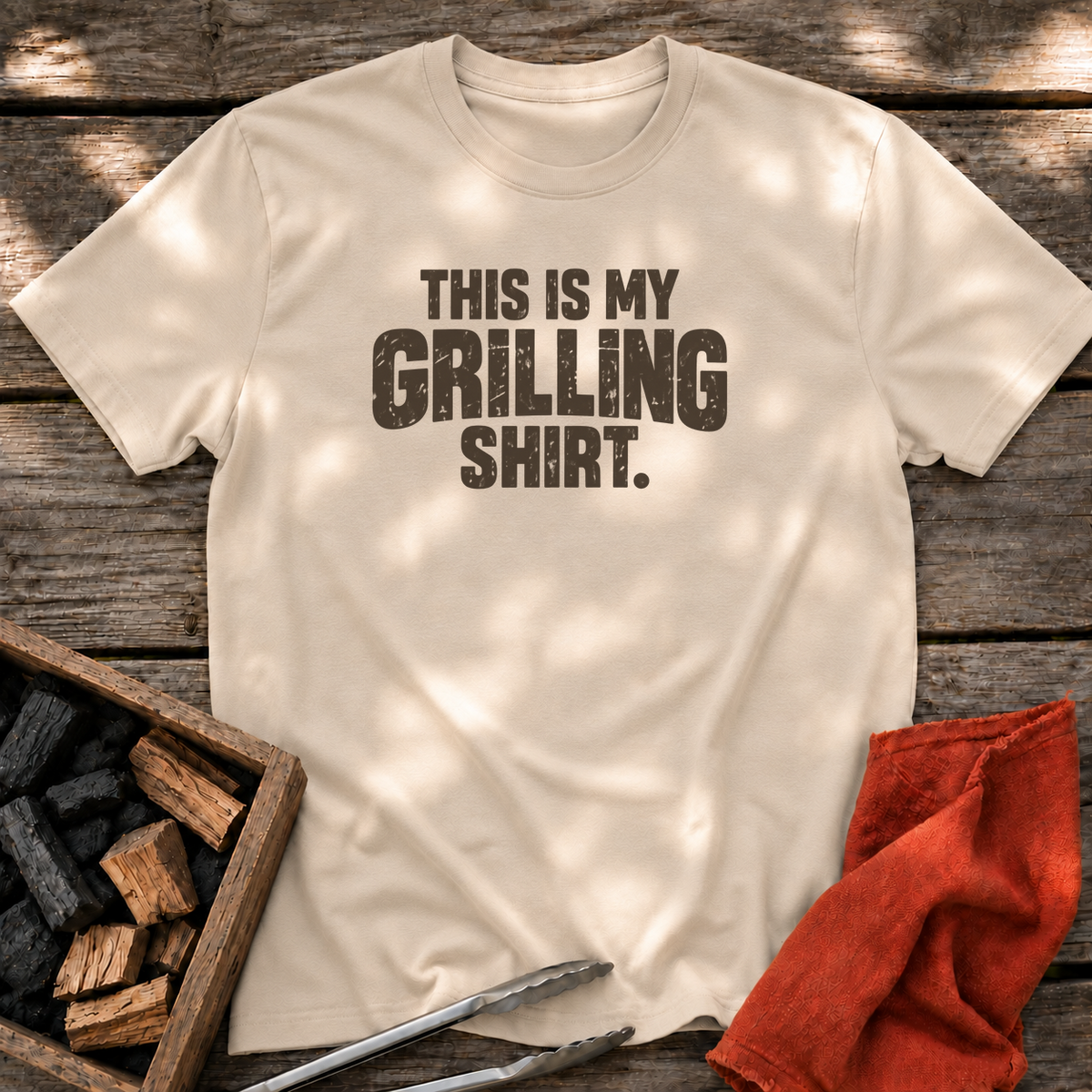Sand T-shirt with the design “This is My Grilling Shirt.” printed on the front.