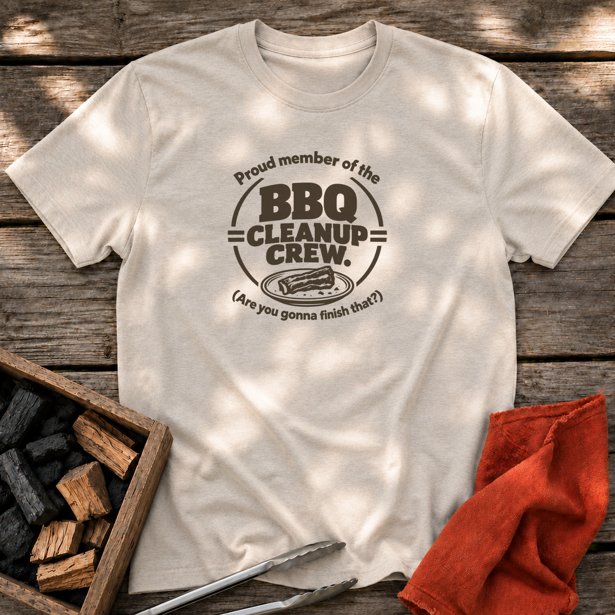 Natural T-shirt with the design “Proud member of the BBQ Cleanup Crew. (Are you gonna finish that?)” printed on the front.