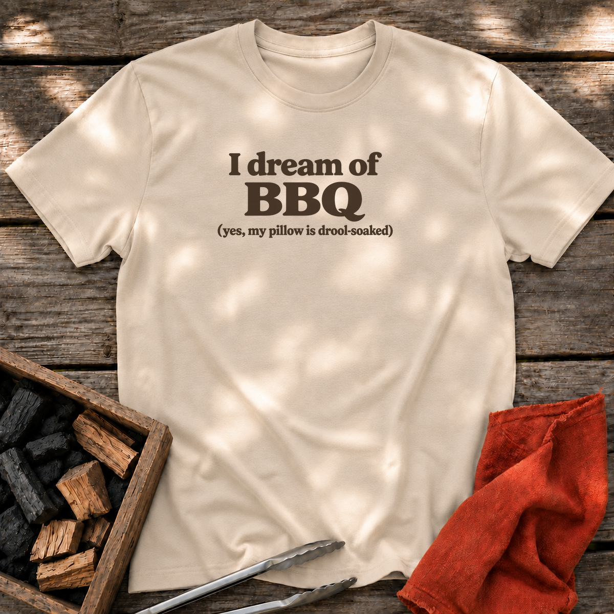 Sand T-shirt with the design “I dream of BBQ (yes, my pillow is drool-soaked)” printed on the front.