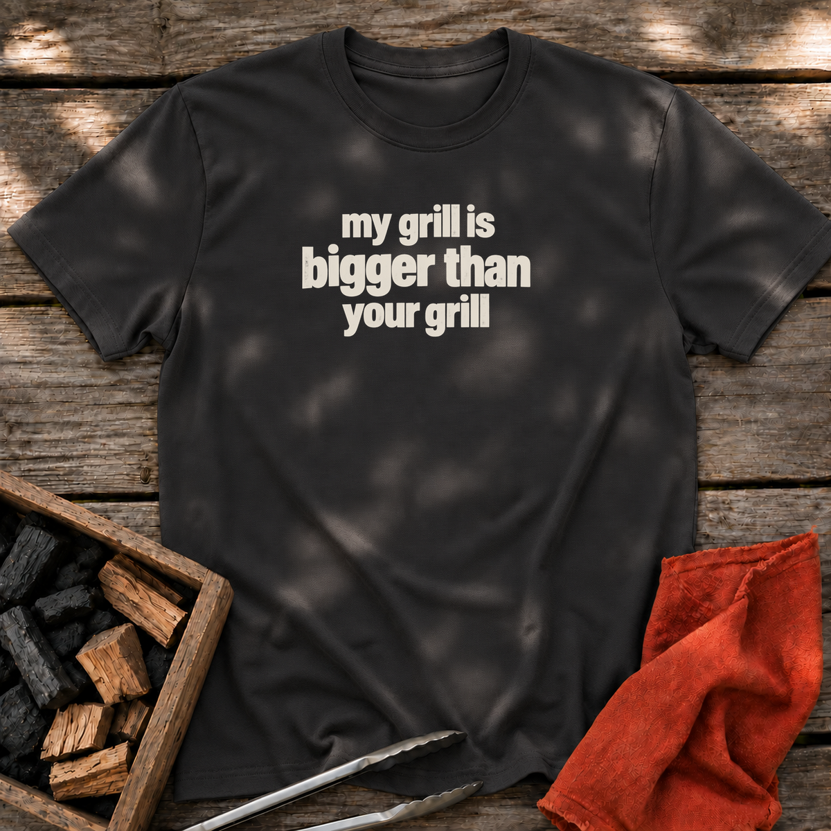 Black T-shirt with the design “my grill is bigger than your grill” printed on the front.