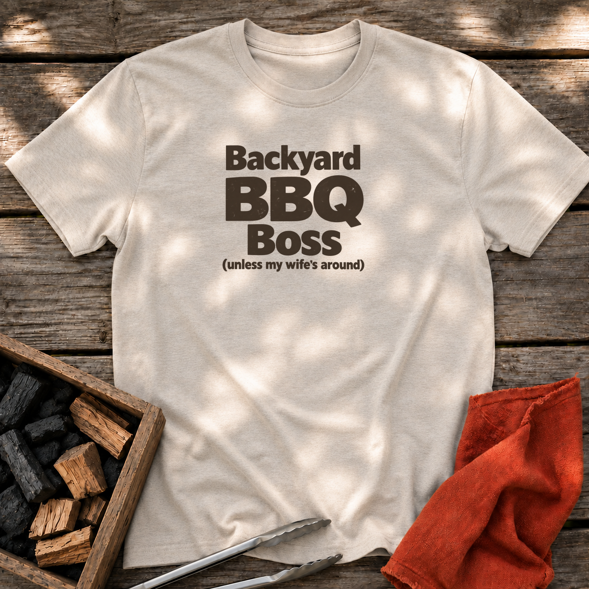 Natural T-shirt with the design “Backyard BBQ Boss (unless my wife's around)” printed on the front.