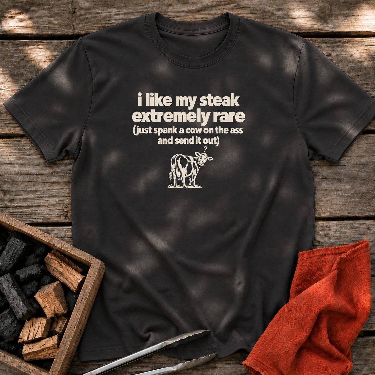 Black T-shirt with the design “i like my steak extremely rare (just spank a cow on the ass and send it out)” printed on the front.