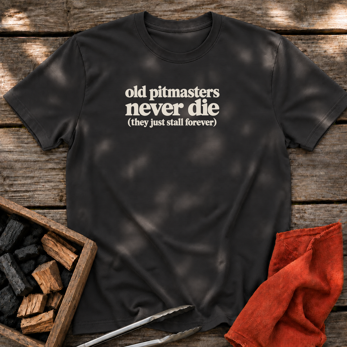 Black T-shirt with the design “old pitmasters never die (they just stall forever)” printed on the front.