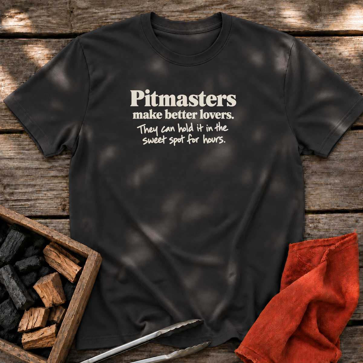Black T-shirt with the design “Pitmasters make better lovers. They can hold it in the sweet spot for hours.” printed on the front.