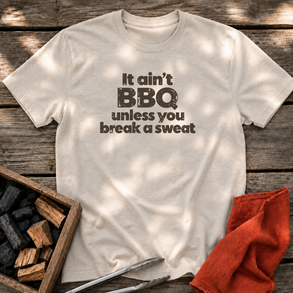 Natural T-shirt with the design “It ain't BBQ unless you break a sweat” printed on the front.