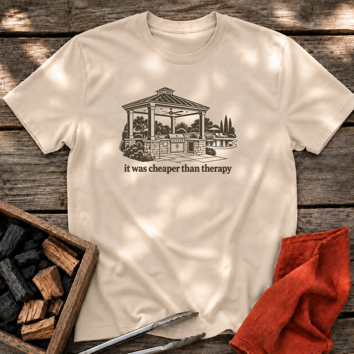 Sand T-shirt with the design “it was cheaper than therapy” printed on the front.